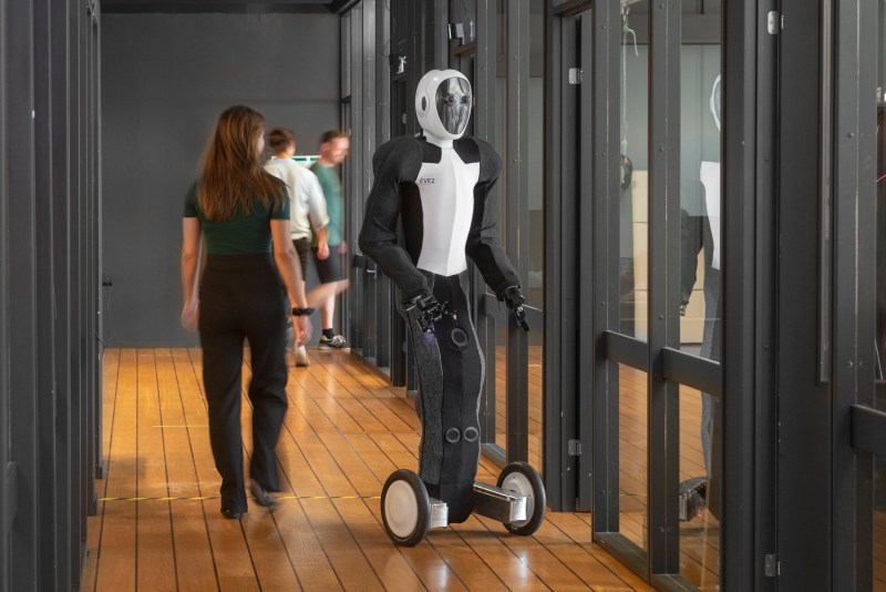 Humanoid robot with people in corridor