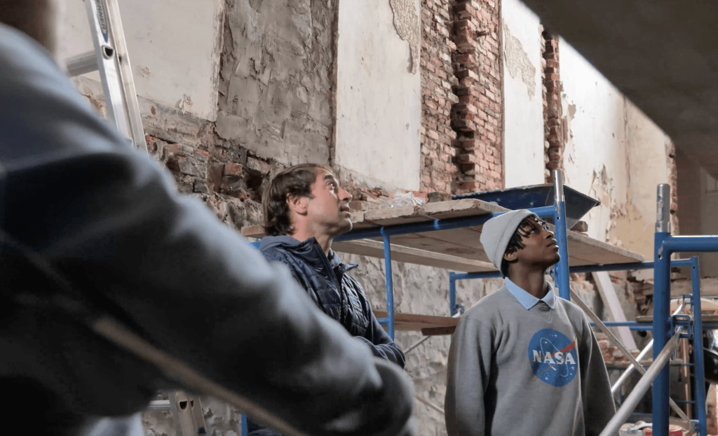 Requity co-founder Michael Rosenband and Carver Vocational-Technical students stand inside the Carver House, which the students are working to renovate.