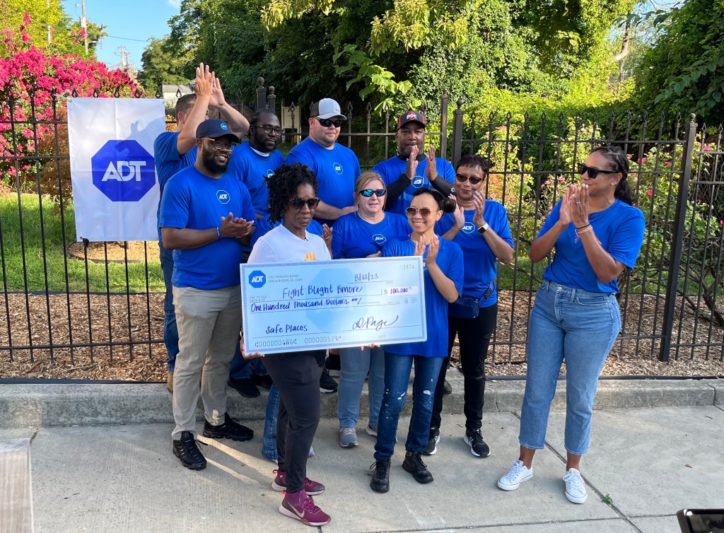 Fight Blight Bmore founder and CEO Nneka N’namdi holds the $100,000 donation check presented by ADT on Aug. 13, 2023.