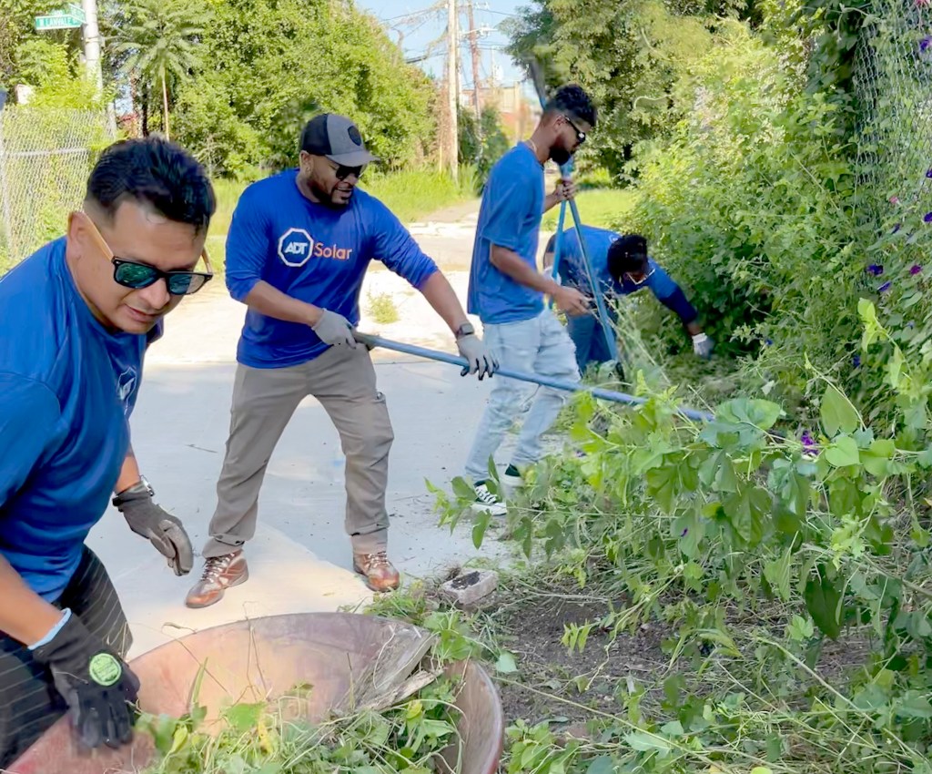 ADT employees work at a community garden volunteer event in Baltimore Aug. 13, 2023.