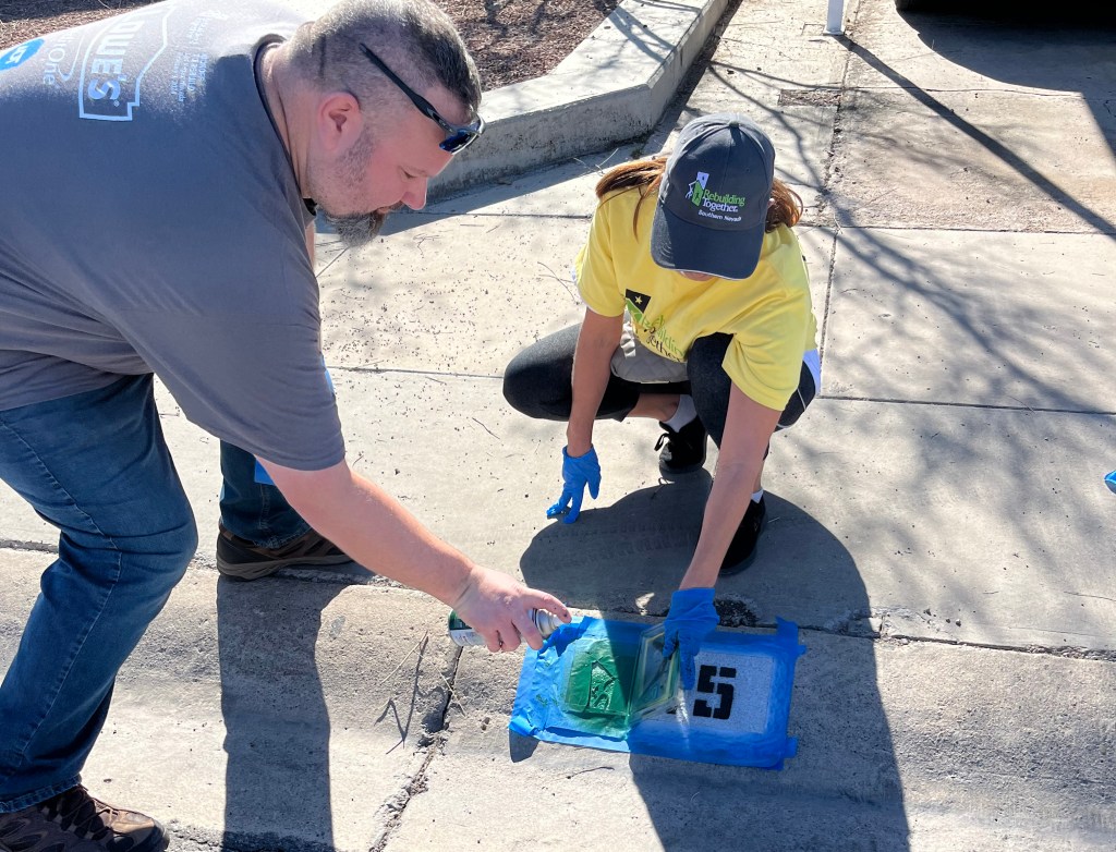 ADT volunteers paint house numbers on the curb at a recent volunteer event in Henderson, Nevada.