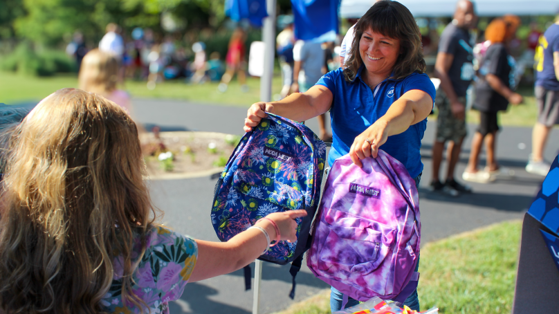 ADT employees distribute free backpacks to children during a National Night Out event in Indianapolis on Aug. 4, 2026.